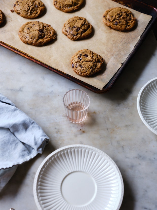 Chickpea Chocolate Chip Cookies on a Marble Counter with Drinking Glass and White Plate