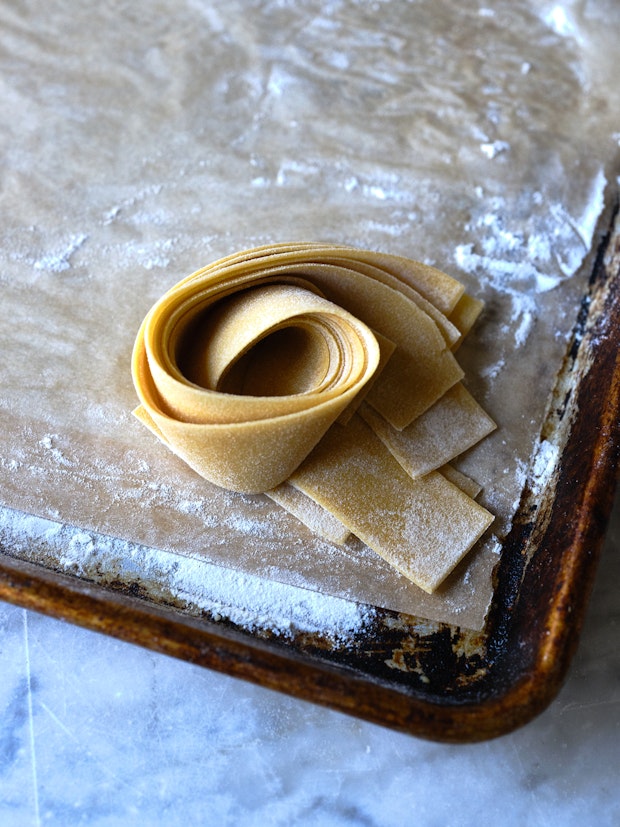 Nest of Pappardelle pasta on a floured sheetpan