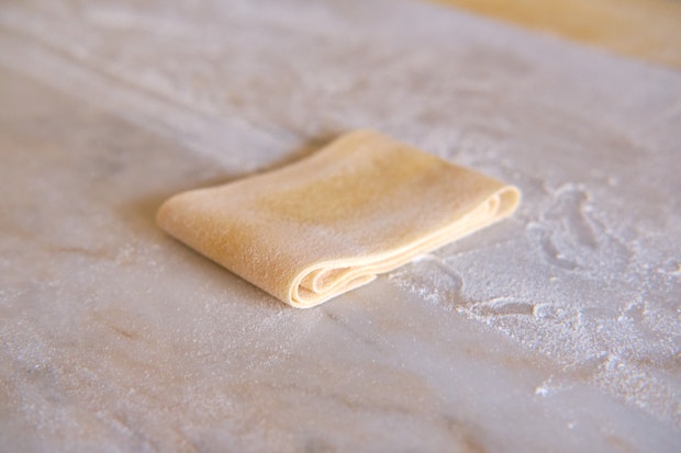 a sheet of fresh pasta rolled up to be cut into tagliatelle