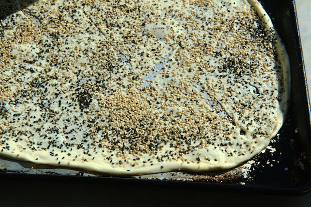 Piadina flatbread dough on a baking sheet before baking