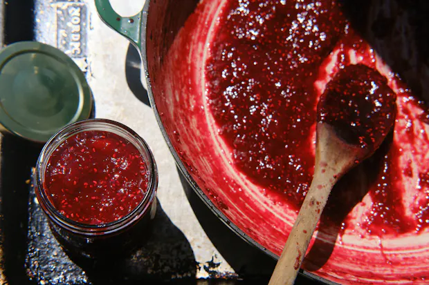 Skillet jam in a pot after cooking and filling glass jar
