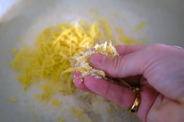 Rubbing lemon zest into sugar with fingers