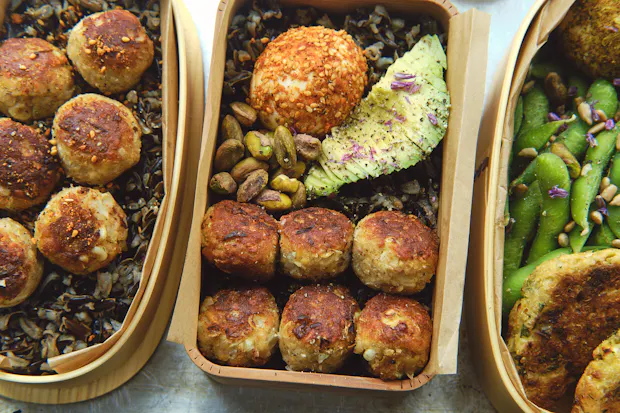 Pan-fried tempeh ponzu balls in a bento box with other lunch items