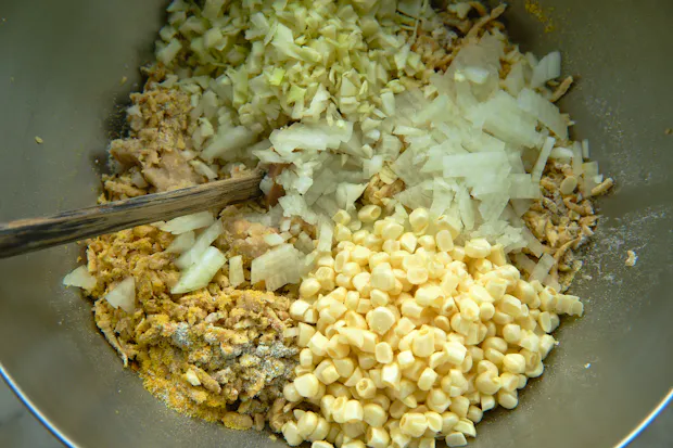 Ingredients for making tempeh ponzu balls in a stainless steel mixing bowl