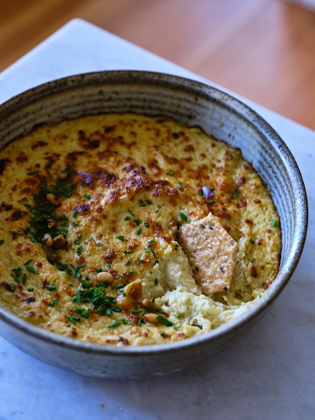 Baked artichoke dip in ceramic bowl