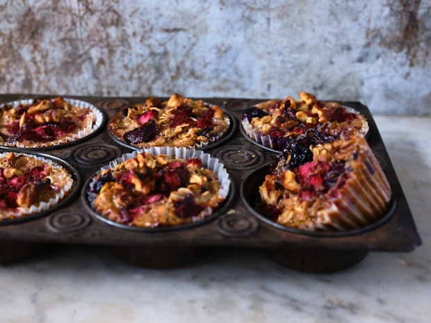 Six baked oatmeal cups with lots of berries, pictured from the side