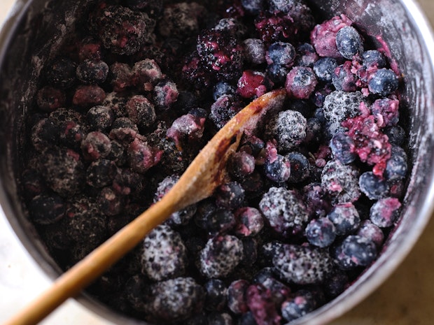 berry pie filling in a mixing bowl with spoon