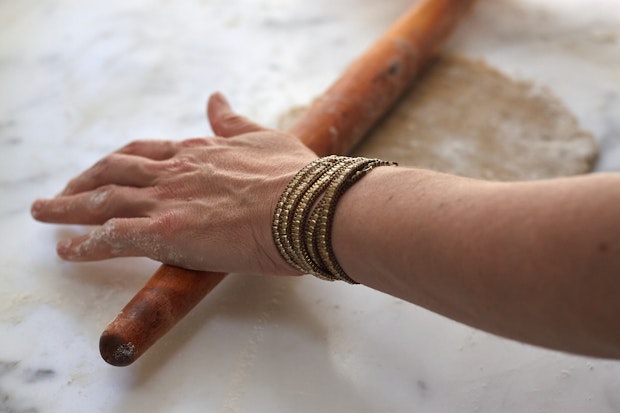 pie crust being rolled out with wood rolling pin