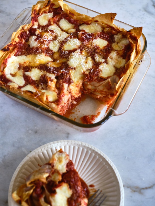 A cheesy lasagna cooling on a counter after baking