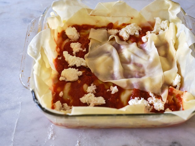 Assembling Lasagna in Glass Baking Dish with Pasta and Tomato Sauce and Cheese