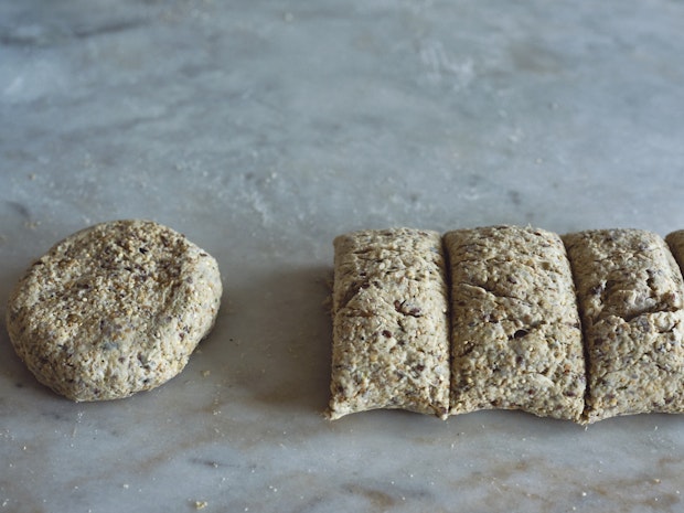 bread dough rolled out on counter and cut into portions