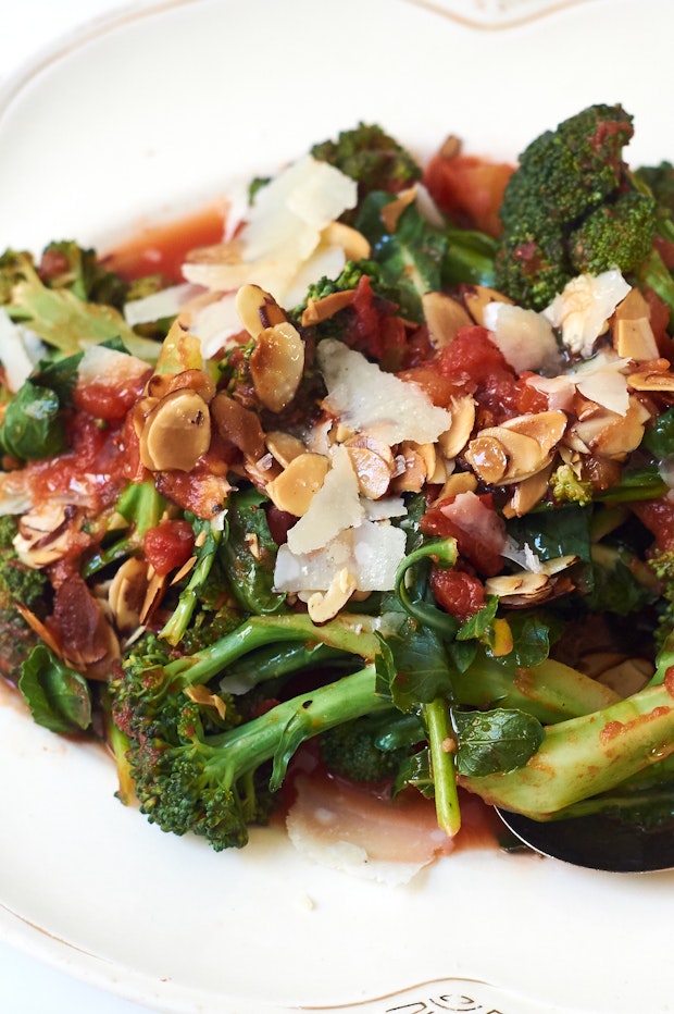 braised broccoli with orange and parmesan served on a plate