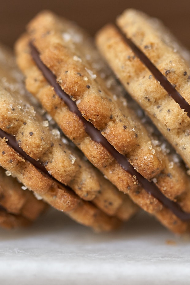 side view of a stack of sandwich cookies each filled with chocolate