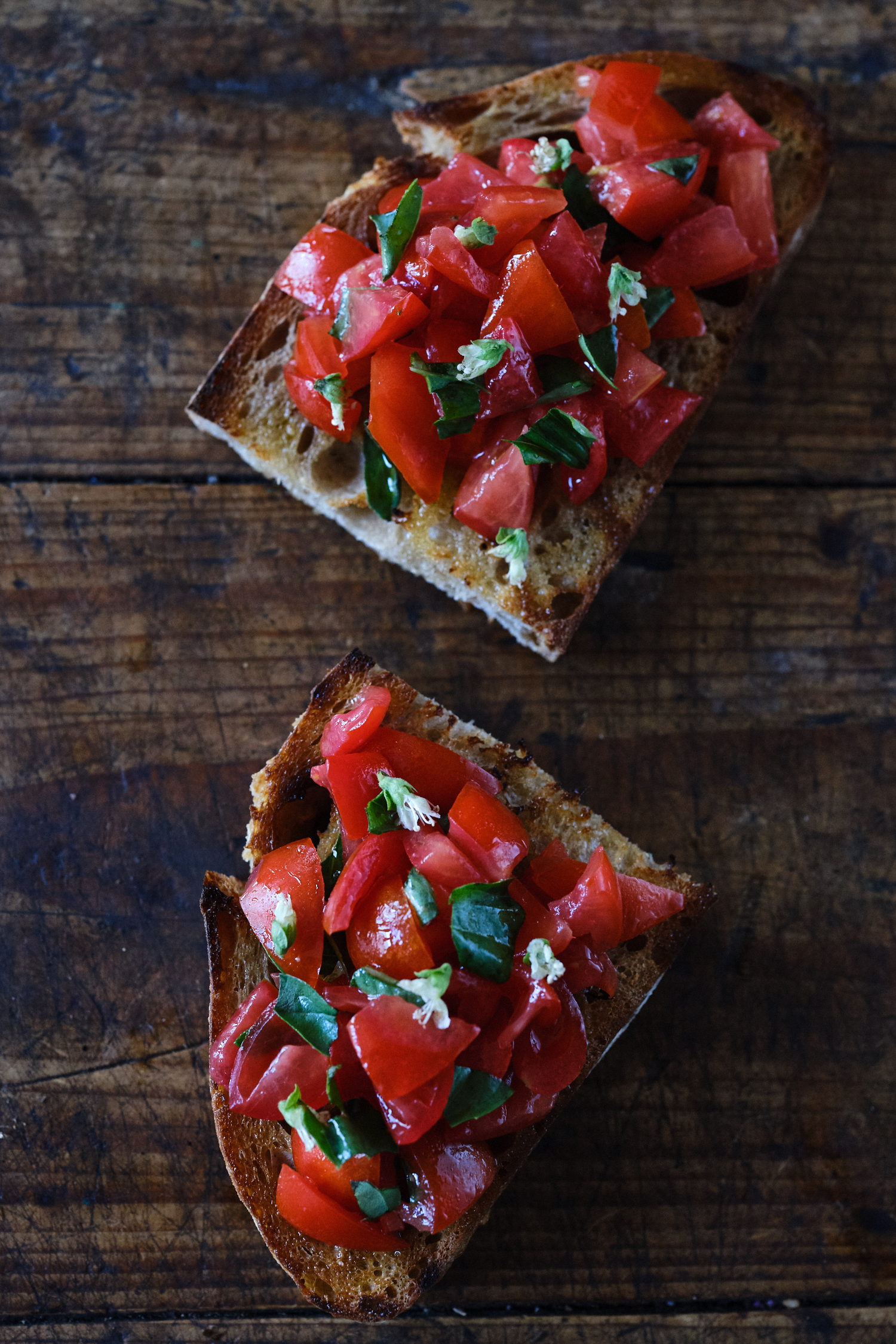 Bruschetta simple con tomates rojos maduros y albahaca