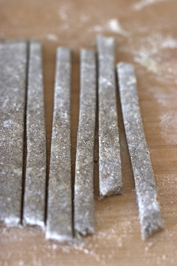 dough for cheese straws rolled out and cut into strips on a counter