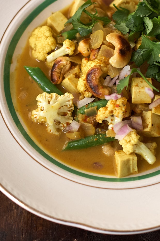 cashew curry in a bowl with cauliflower, tofu, and green beans