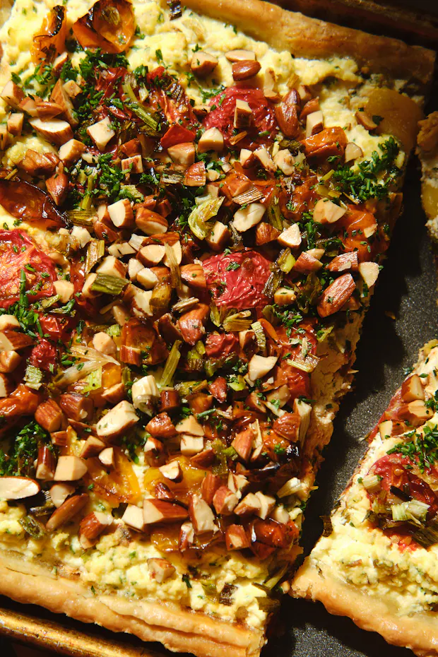 cherry tomato tart with burnt scallion ricotta filling in a tart pan