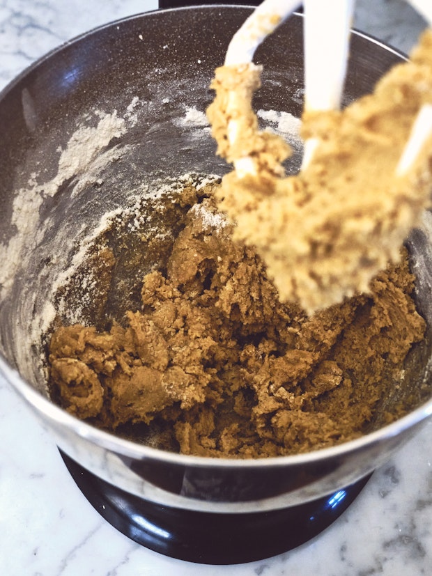Chocolate chip cookie dough in the bowl of a mixer”   border=