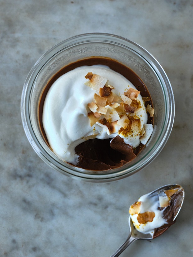 chocolate pudding in a glass bowl with whipped cream on top