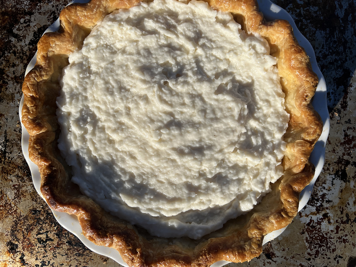 a fully baked pie crust filled with coconut cream pie filling