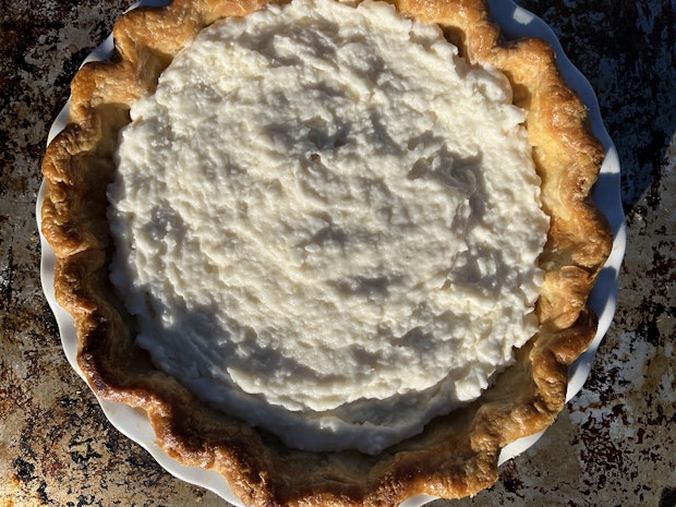 a fully baked pie crust filled with coconut cream pie filling