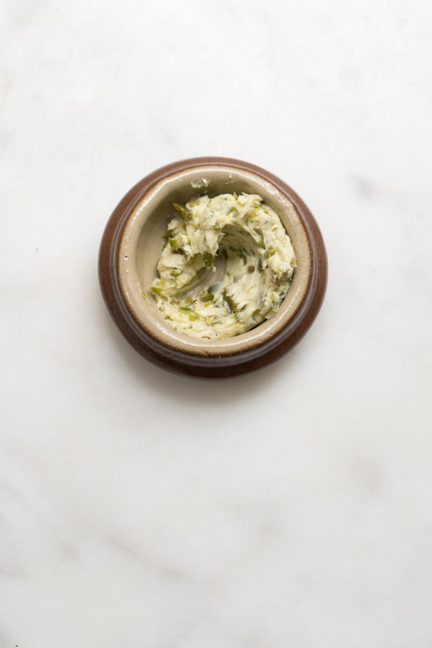 Burro composto di olive verdi all'aglio in una piccola ciotola da portata