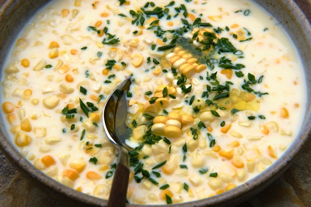 creamed corn in a serving bowl with a spoon