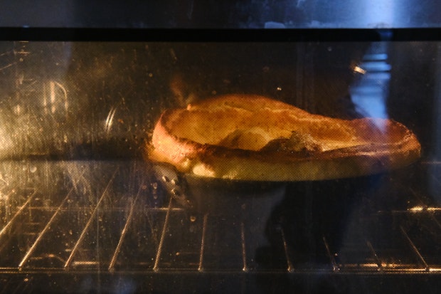 dutch baby pancake puffing up while baking in an oven