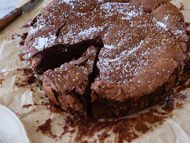 Close up photo of Flourless Chocolate Cake with a Slice Cut from It