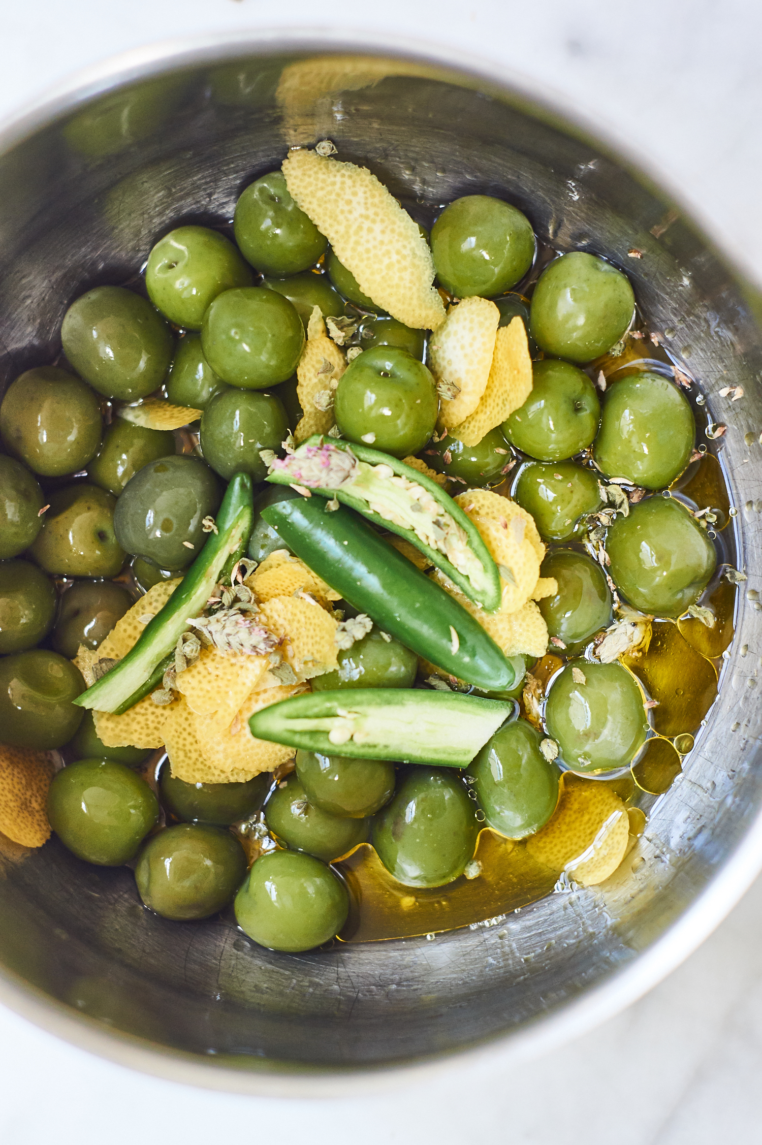 Close-up photo of ingredients for marinated olive in a metal bowl