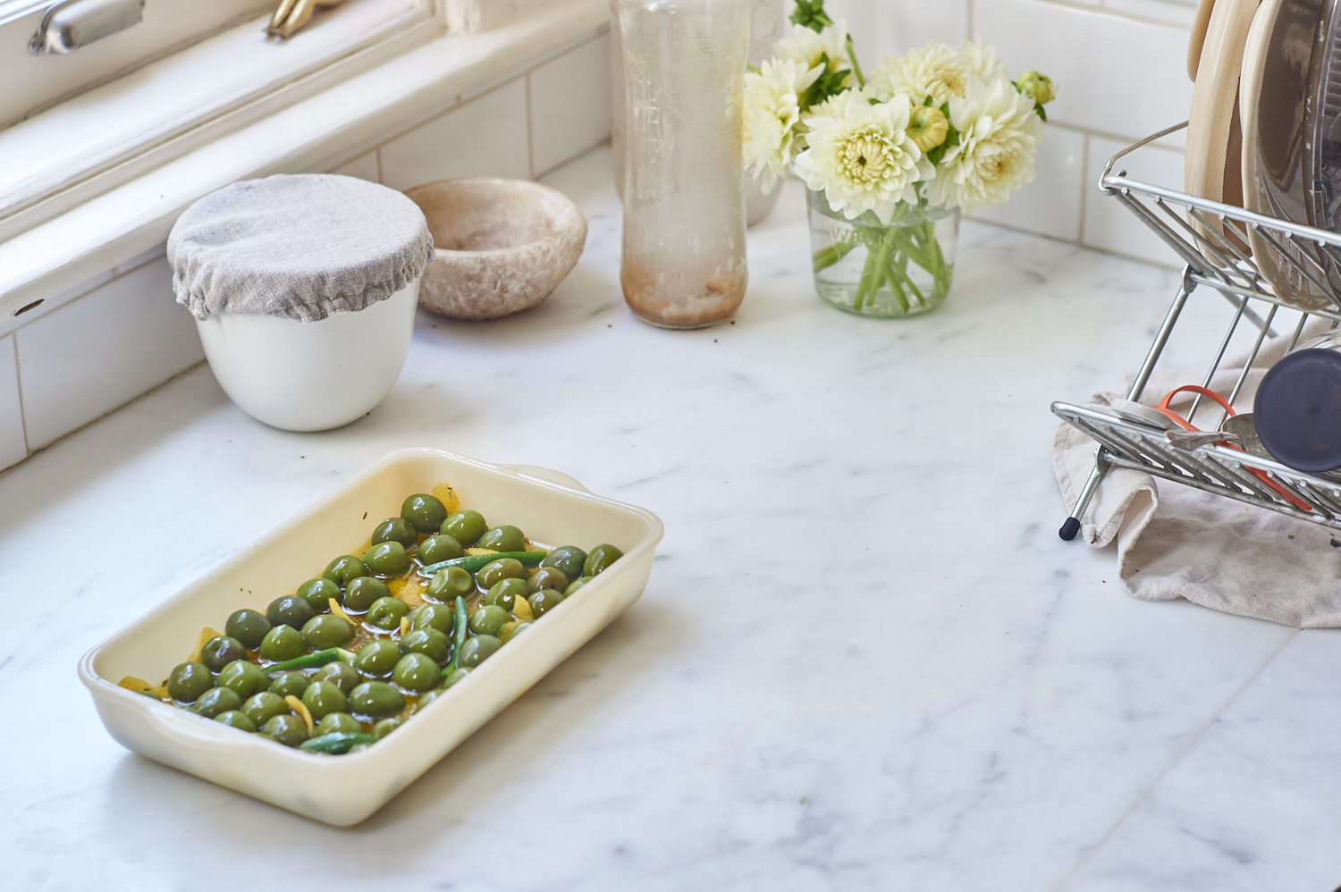 Marinated olives in a baking dish on a counter