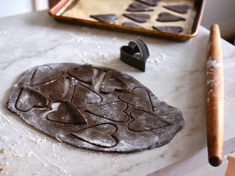 Gingerbread koekjesdeeg gestempeld met harten op marmeren toonbank