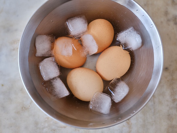 hard boiled eggs cooling in a bowl of ice and water