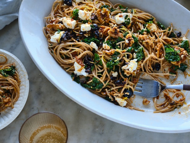 spaghetti tossed with harissa oil, kale, black olives and walnuts served on a platter