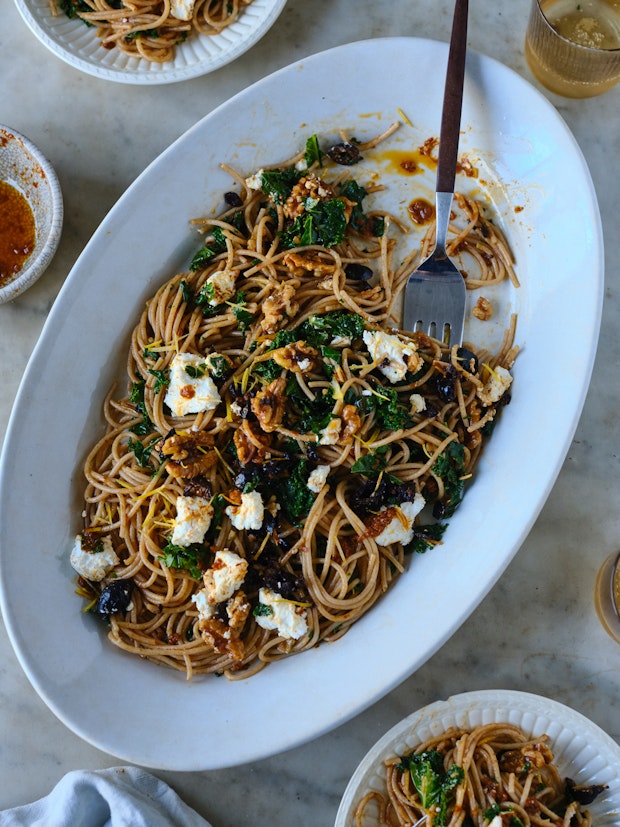 spaghetti tossed with harissa oil, kale, and walnuts served on a platter