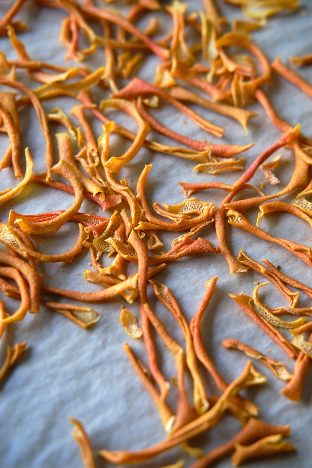 dry citrus peel on a parchment-lined baking sheet