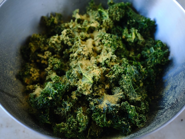 ingredients for kale chips in a mixing bowl