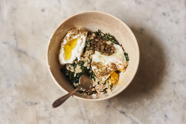 Rice bowl made with brown rice and kale, topped with an egg and yogurt