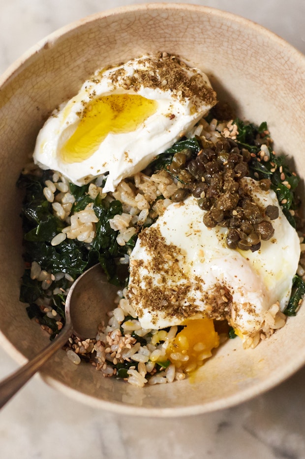 Rice bowl made with brown rice and kale, topped with an egg and yogurt