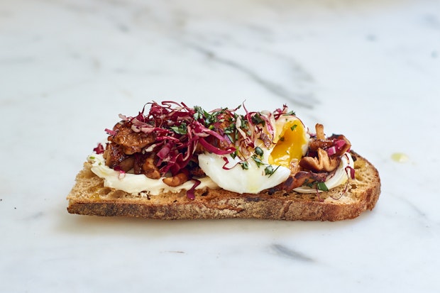 labneh smeared into a piece of sourdough and topped with an egg and other ingredients