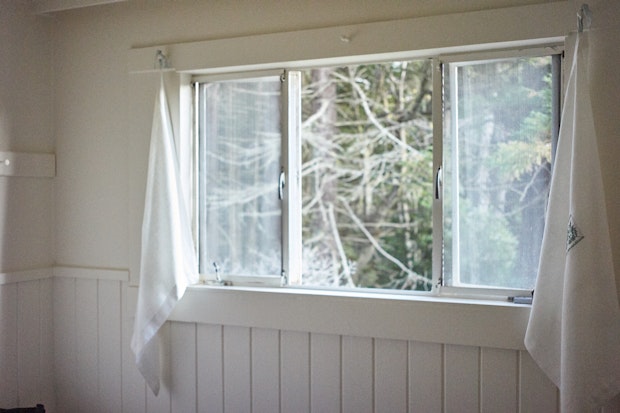 view through cabin window with handmade curtains