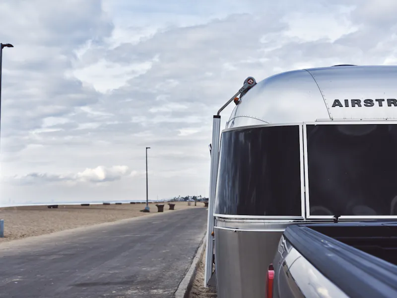 Airstream-aanhangwagen vanaf de voorkant geparkeerd op het strand
