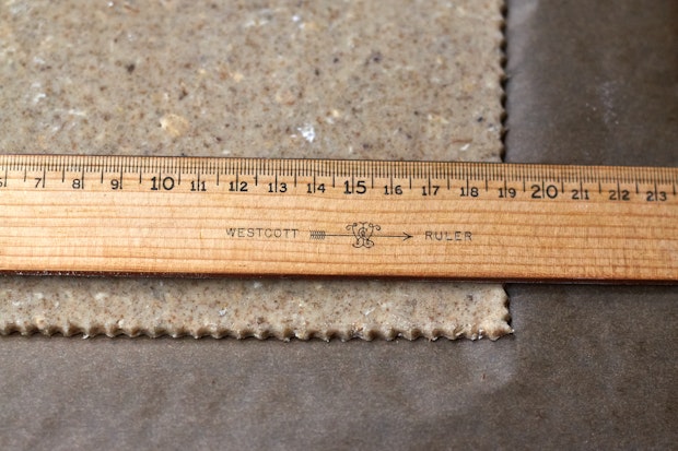 a ruler being used to cut crackers into straight lines