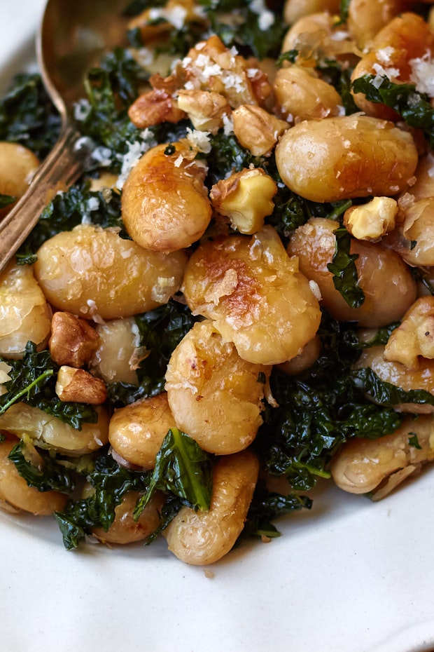 pan-fried beans with kale on a white plate