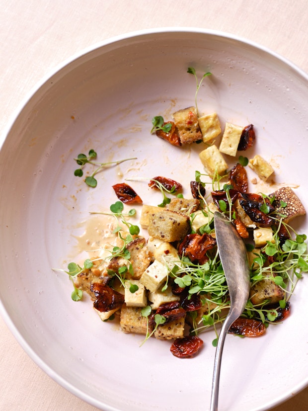 bowl of panzanella made with bread, tomatoes, and sprouts