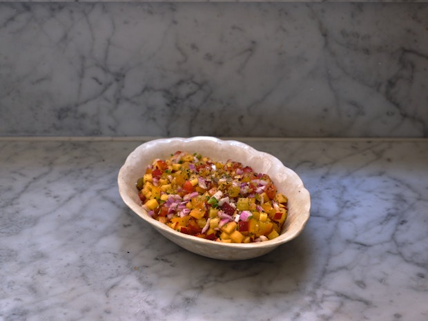 peach salsa in a serving bowl on a marble counter