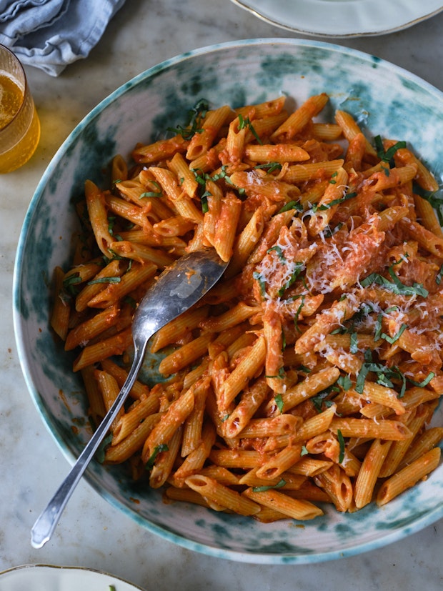 penne alla vodka in a bowl with creamy sauce finished with lots of Parmesan cheese