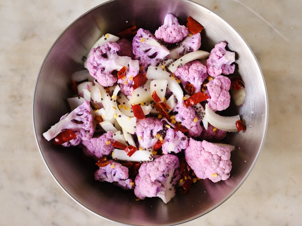 Cauliflower florets, onions, mustard seeds and chile in a glass mason jar