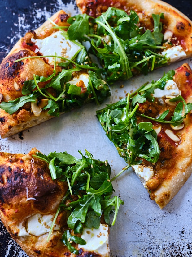 Pizza with red sauce and arugula as pizza toppings