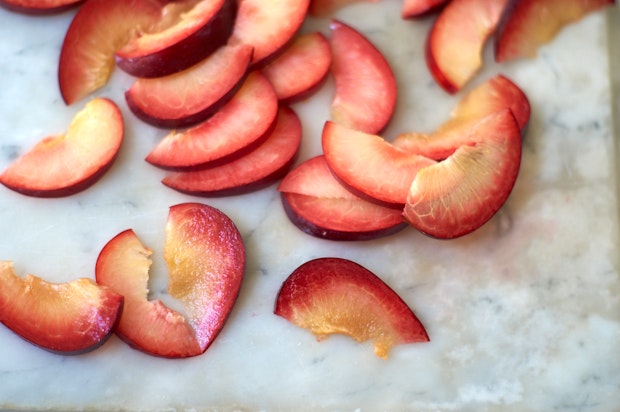 Cut pluots on a marble counter